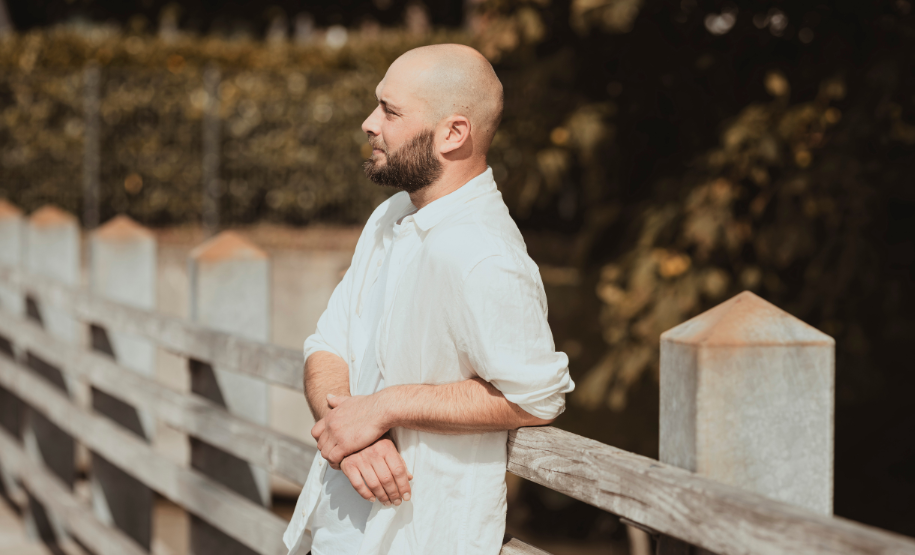 Beziehungscoach steht nachdenklich an einer Brücke und blickt in die Ferne