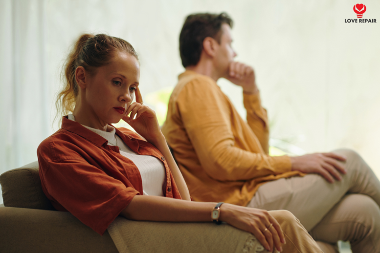 Paar sitzt emotional distanziert nebeneinander auf dem Sofa – Beziehungskonflikt durch Bindungsangst