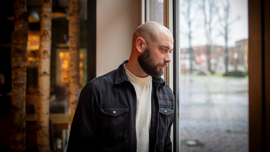 Beziehungscoach Florian Pohl blickt nachdenklich aus dem Fenster - Symbol für innere Stabilisierung und psychische Gesundheit nach einer Trennung
